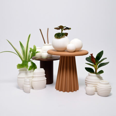 an array of tiny white 3d printed vases filled with tiny green sprigs of plants around a brown 3d printed columnar table