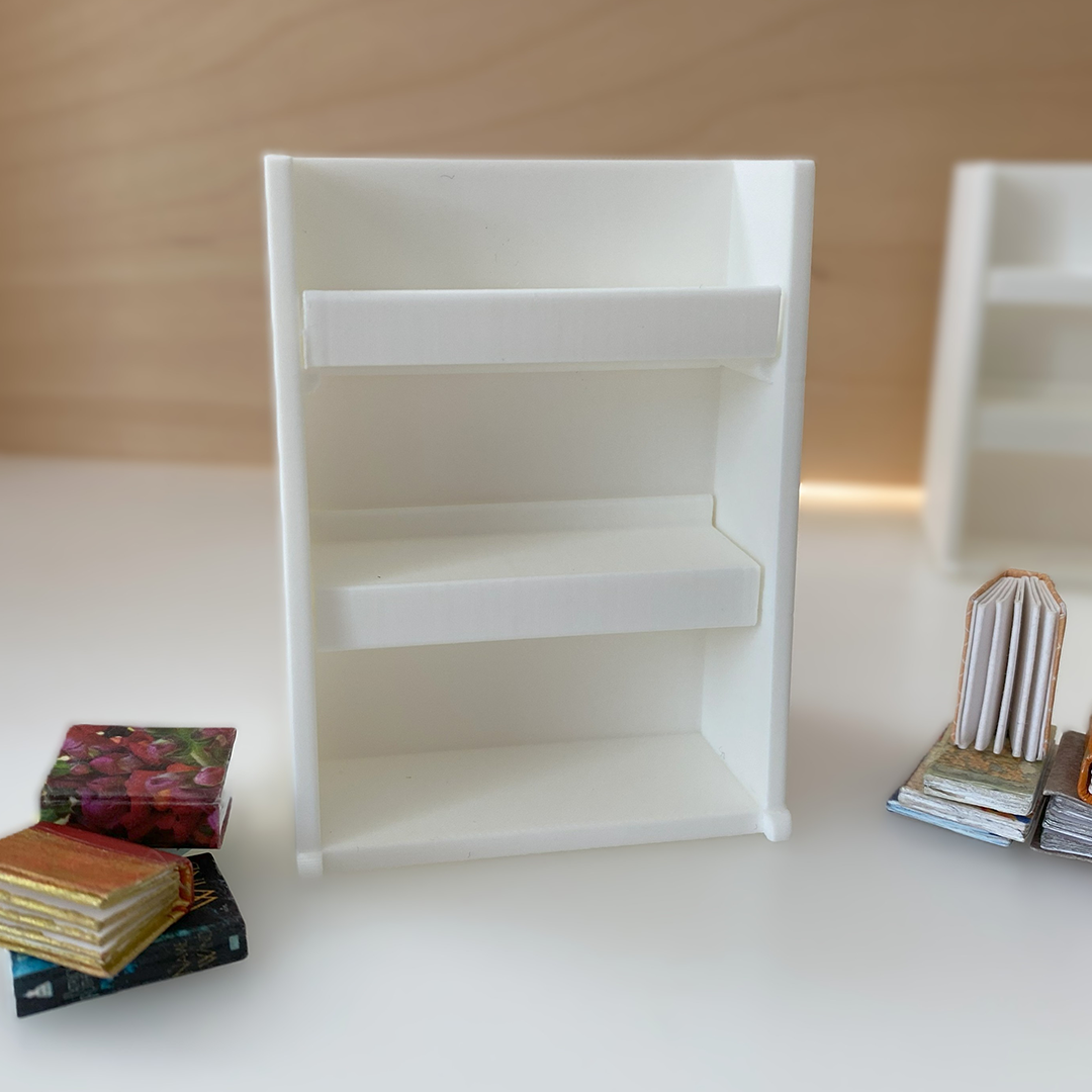 a photo of an empty tiny bookshelf with tiny books nearby